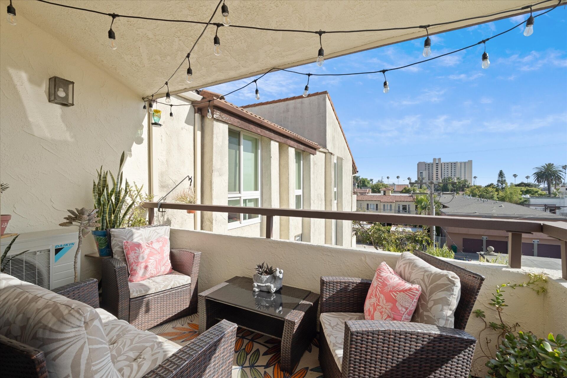 Private covered balcony with string lights and lounge seating