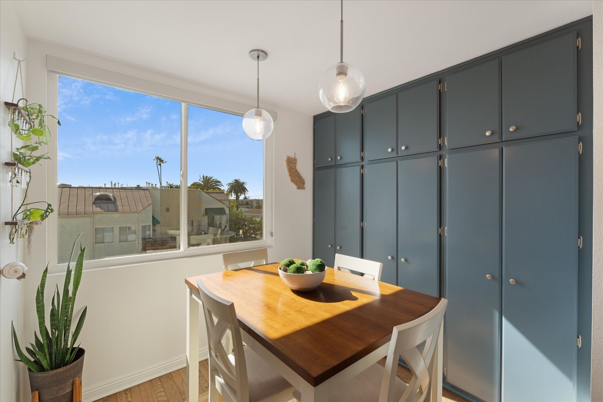 Sunny breakfast nook with pendant lighting and built-in cabinetry