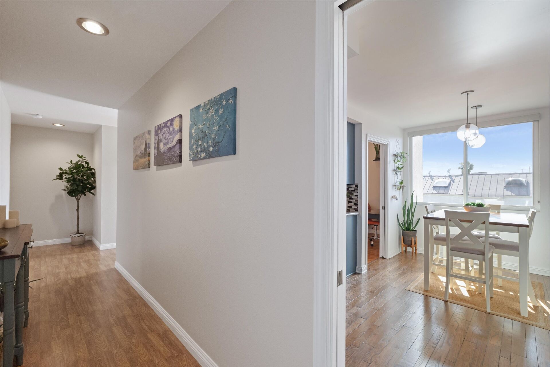 Entryway hallway with hardwood floors connecting living and dining areas