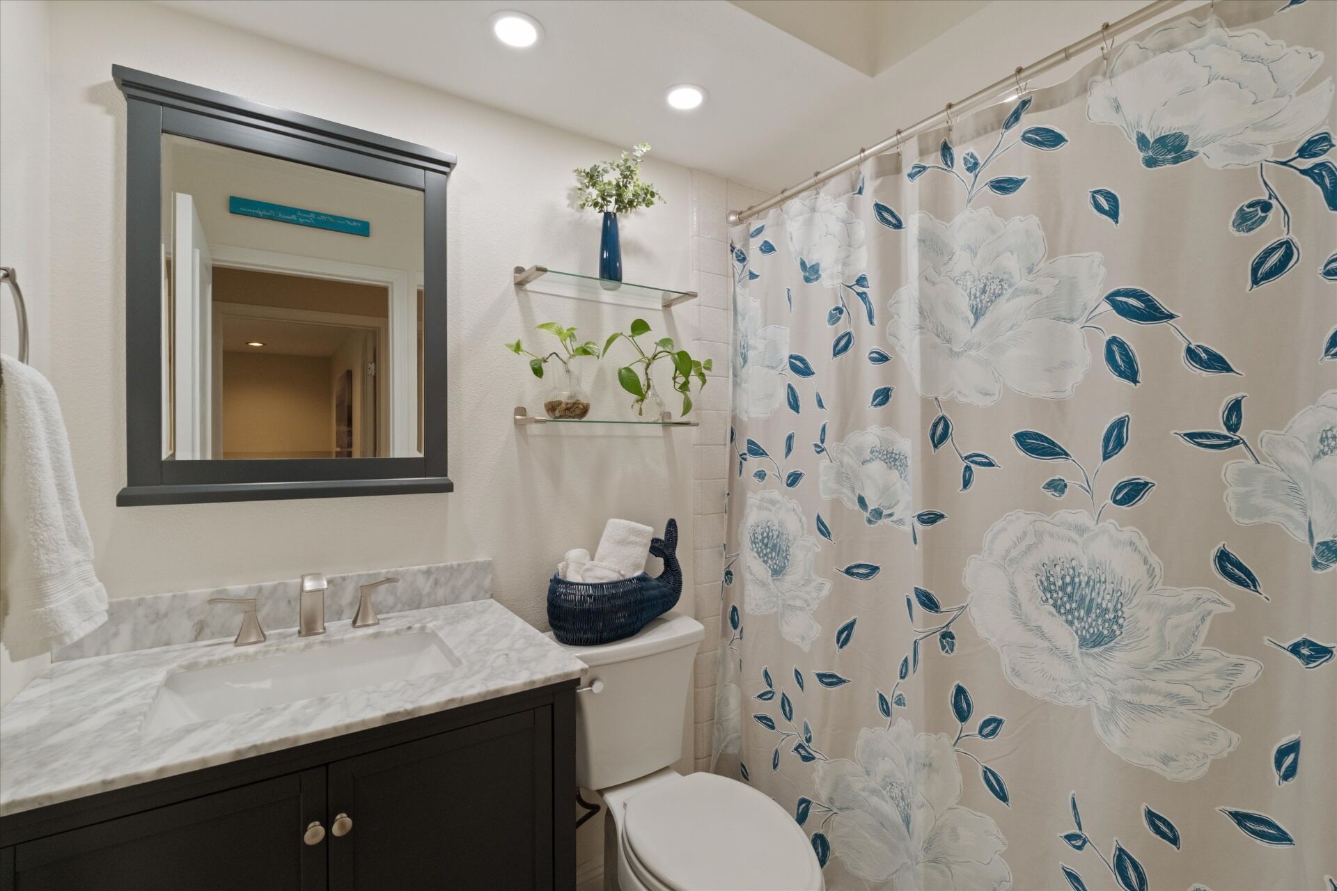 Guest bathroom with marble vanity and tub/shower combo