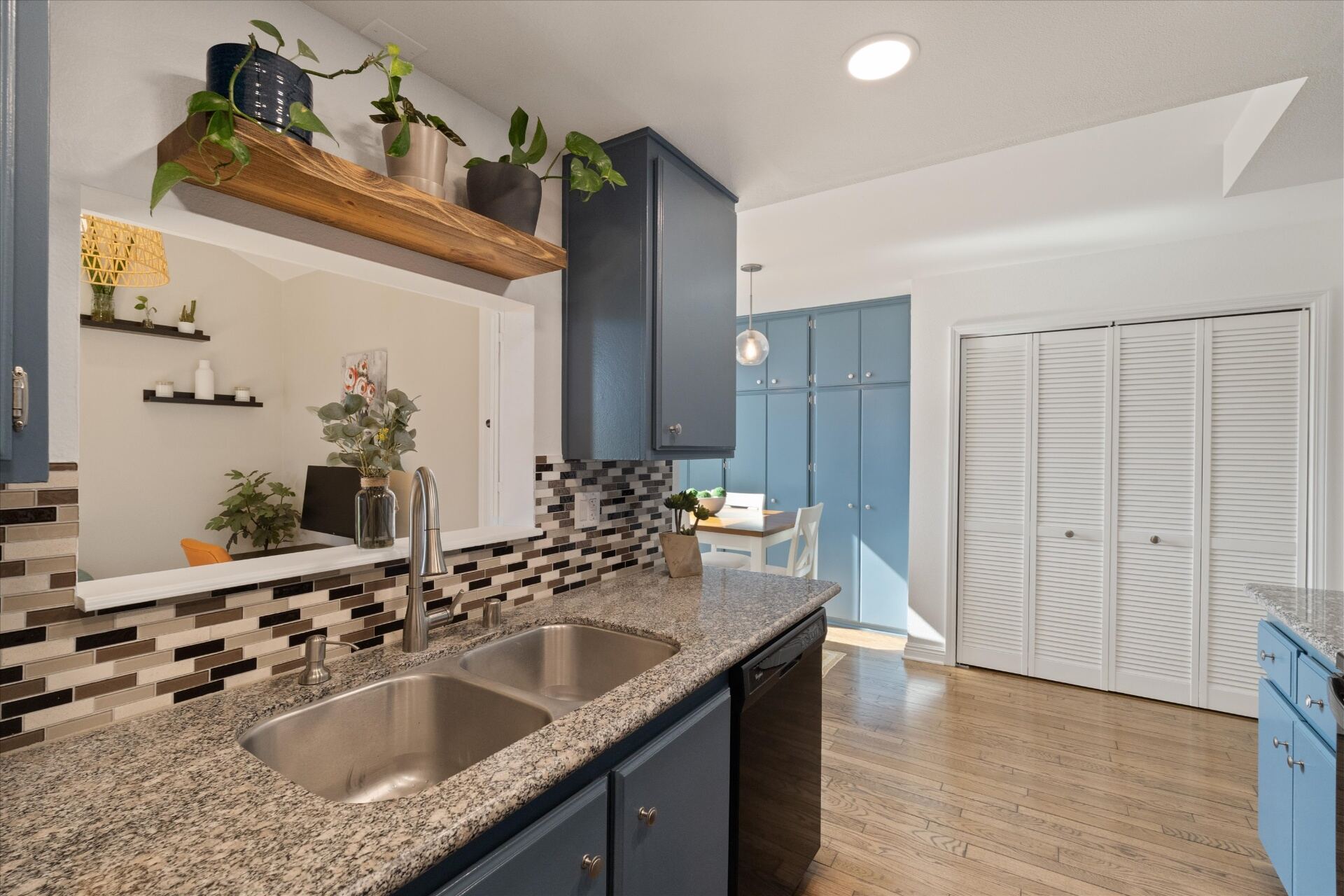 Kitchen with granite counters, double sink, and tile backsplash
