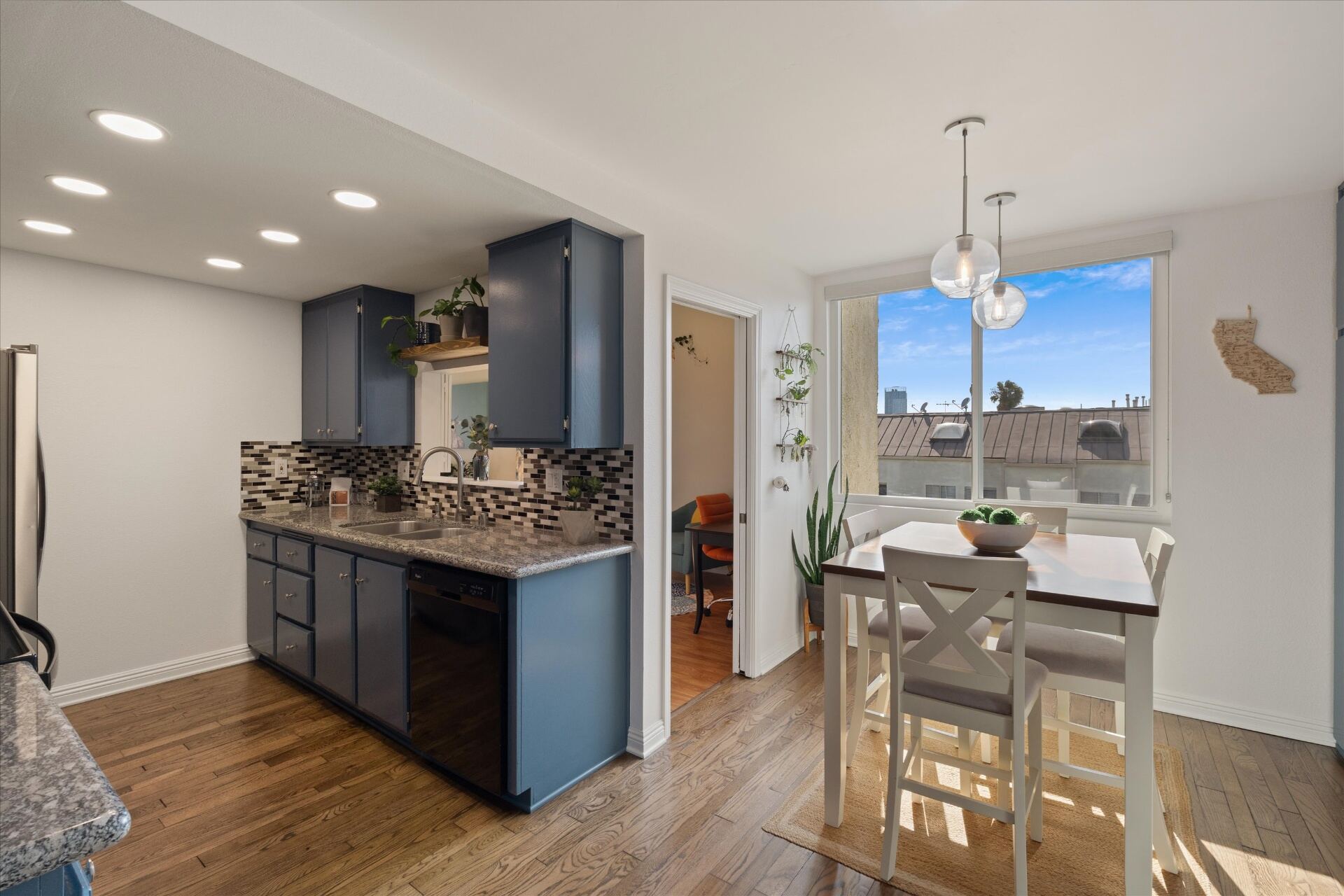 Kitchen opening to bright dining area with city views