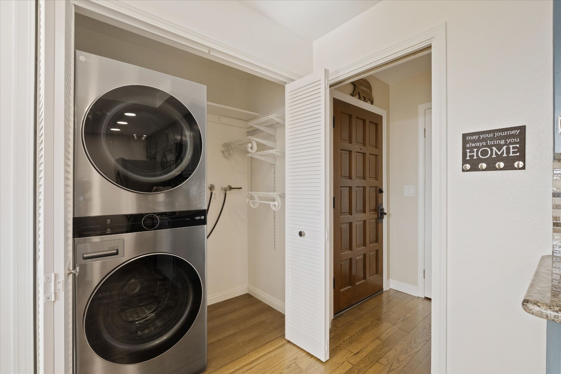 In-unit stacked LG washer and dryer near the entry
