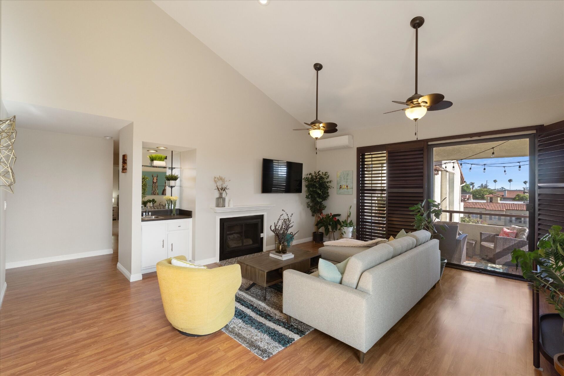 Top-floor living room with soaring vaulted ceilings, fireplace, and balcony access