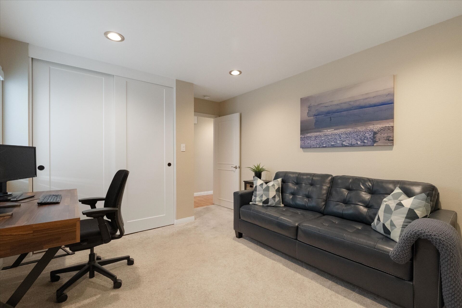 Second bedroom currently styled as an office and den with sliding closet doors